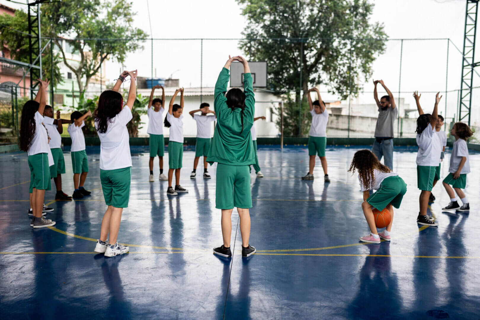 Group of students exercising outdoors with a teacher.