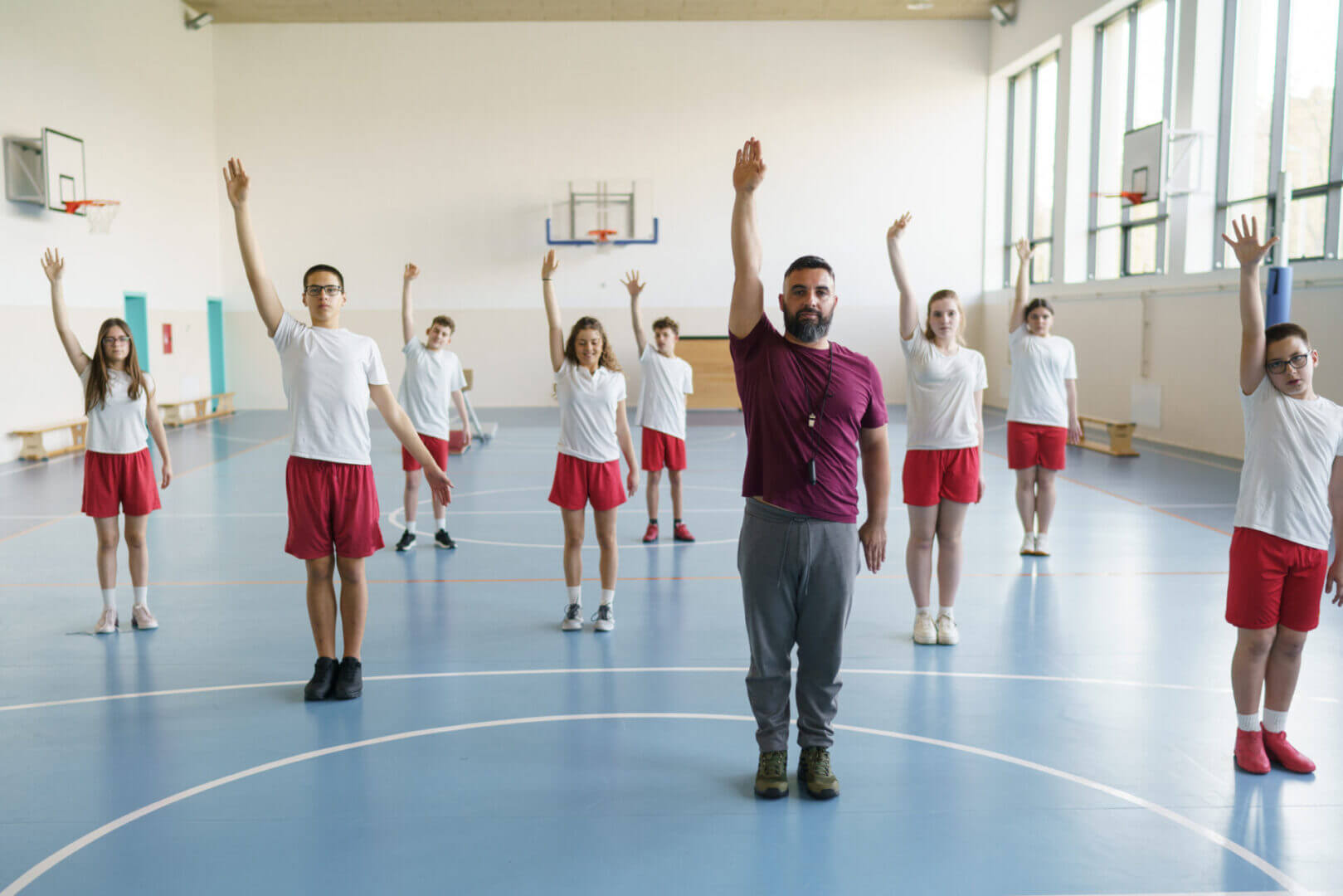Group exercise class led by instructor in gym.