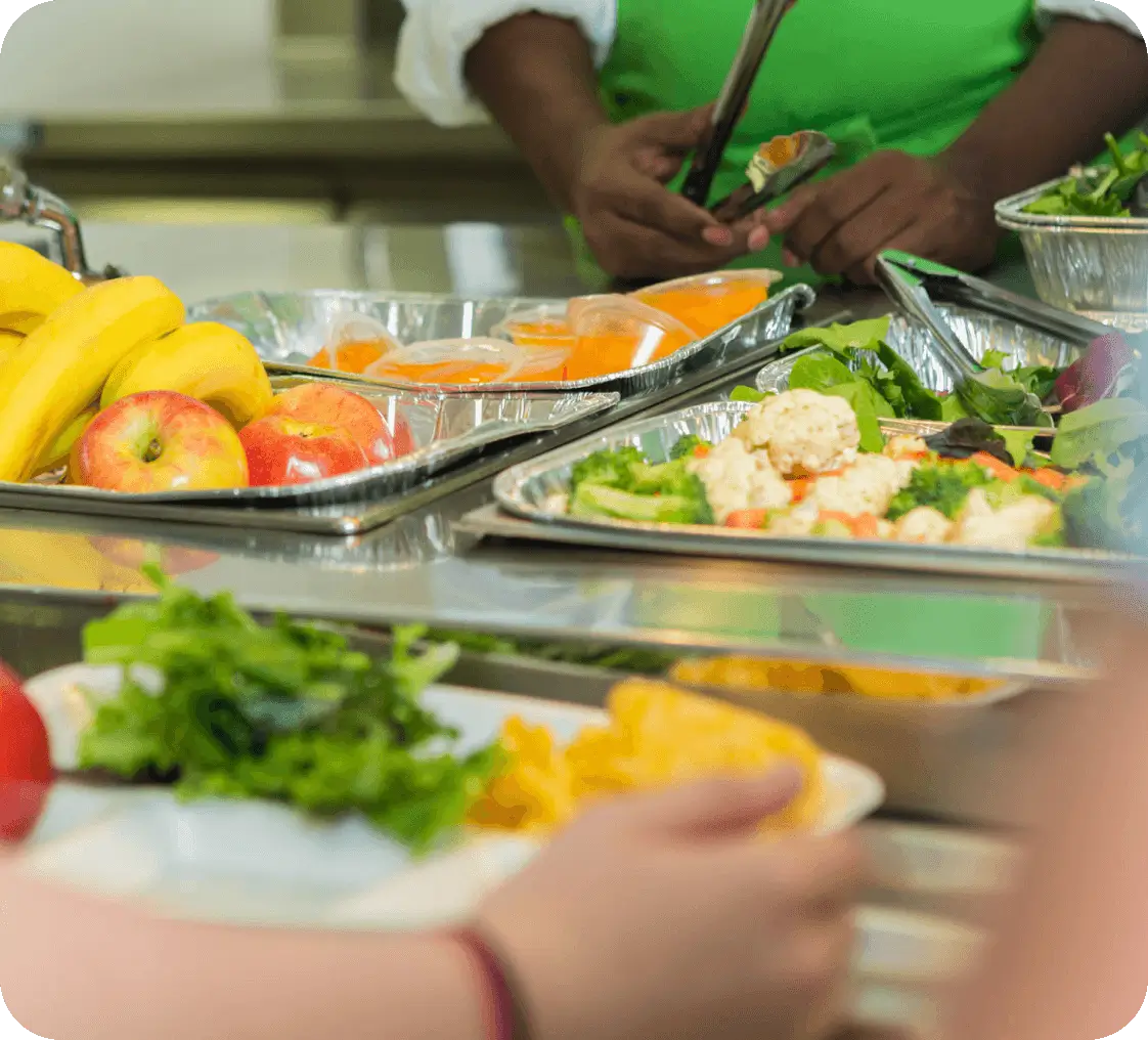 People serving themselves food from a buffet with various dishes.